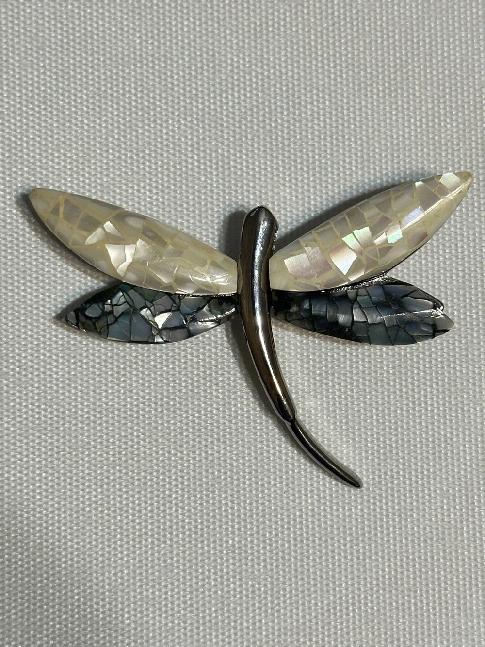 Vintage dragonfly brooch featuring a sleek silver-tone or chromed metal